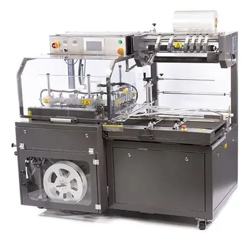 An enclosed automatic L-sealer with guarding, a film roll on top, and a touchscreen control.